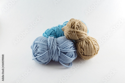 Multi-colored skeins of woolen threads of light background. Different sizes. Set of colorful rolls of yarn. Can be used for online stores.