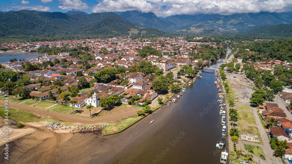 Aerial view to river Pereque-Acu in historic town Paraty with green mountains covered with white clouds in background, Unesco World Heritage, Brazil