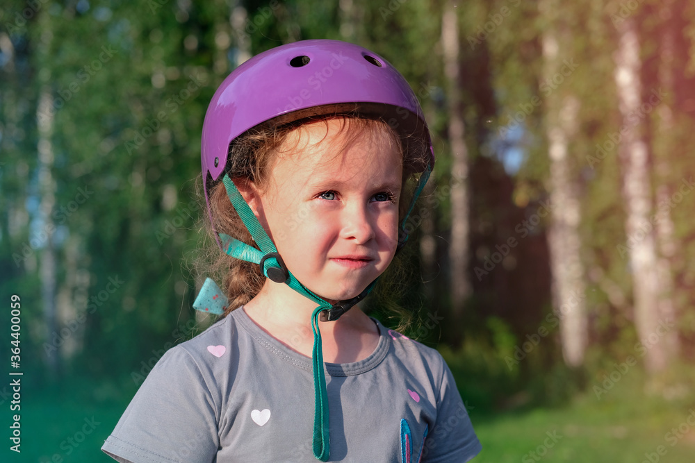 little girl in protective helmet looking at distance. happy smiling girl outdoors going to roller skate. active lifestyle for kids. summer leisure concept. little girl in protective helmet looking at distance. happy smiling girl outdoors going to roller skate. active lifestyle for kids. summer leisure concept.