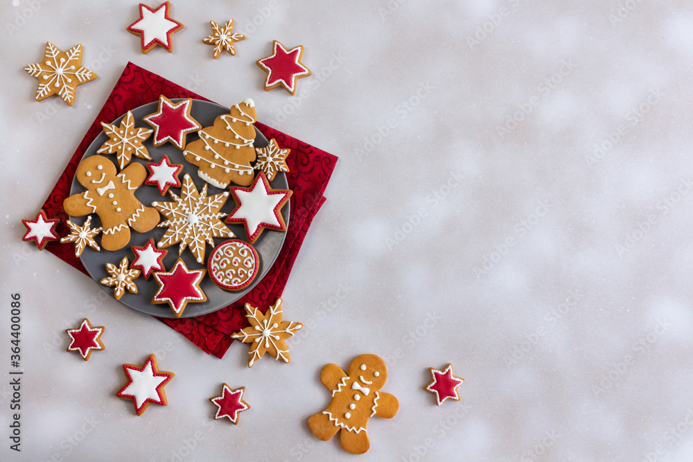 Top view of gingerbread cookies on plate and white snowy background with copy space. Tasty glazed painted cookies: snowflakes, stars, gingerbread man. Merry Christmas and Happy New Year! Top view of gingerbread cookies on plate and white snowy background with copy space. Tasty glazed painted cookies: snowflakes, stars, gingerbread man. Merry Christmas and Happy New Year!
