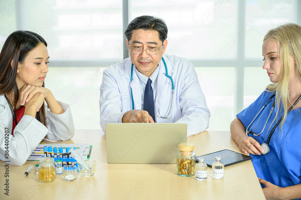 Obraz premium Group of doctors wearing formal white coat and blue scrubs suit, Teamwork brainstorm meeting with computer laptop at the hospital.