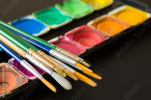Colorful of Watercolor palette and paintbrush on a black background