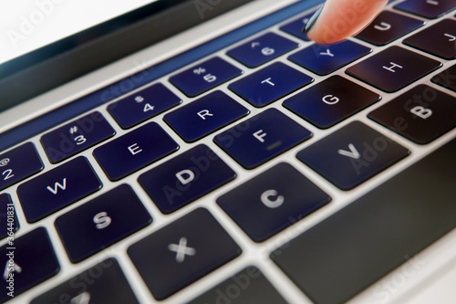 Valokuva Closeup of laptop keyboard with finger typing