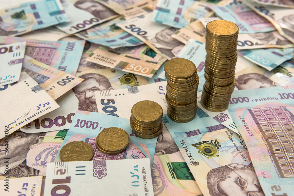 Close up coin stacked growing as financial chart lying on ukraine money as background. For business growth Close up coin stacked growing as financial chart lying on ukraine money as background. For business growth