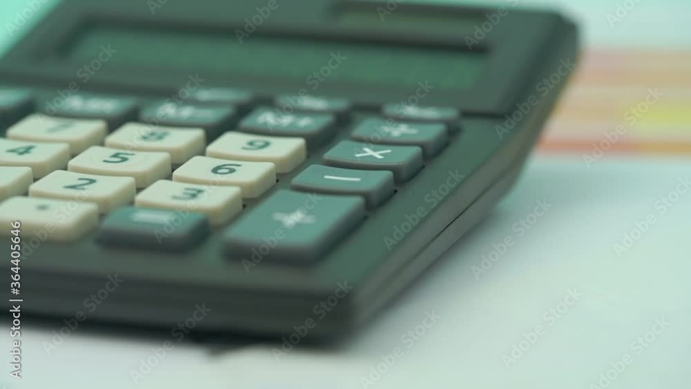 person counts pressing buttons on outdated calculator and writes sum with fountain pen on table slow motion extreme closeup person counts pressing buttons on outdated calculator and writes sum with fountain pen on table slow motion extreme closeup
