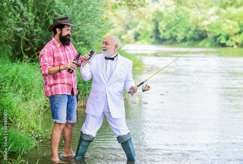 Fishing and drinking beer. Men relaxing nature background. Fun and relax. Weekend time. Bearded man and elegant businessman fishing together. Fishing skills. Set up rod with hook line and sinker