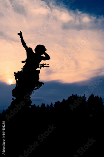 The silhouette of a motorcyclist at sunset. Moto rider making a stunt on his motorbike.