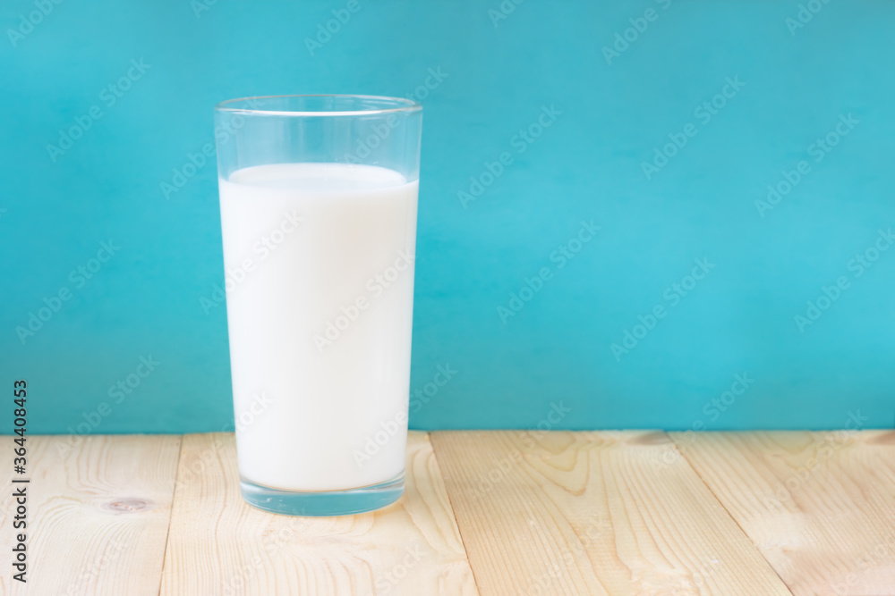 Glass of fresh milk on blue background.Single object Glass of fresh milk on blue background.Single object