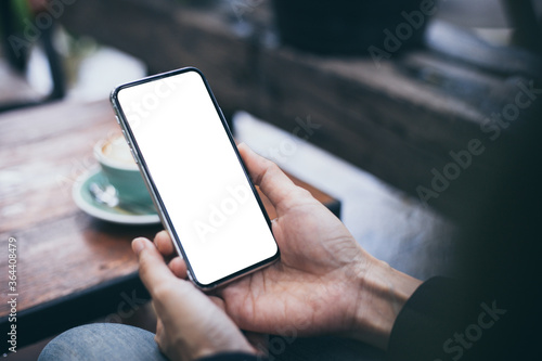 cell phone mockup image blank white screen.woman hand holding texting using mobile on desk at coffee shop.background empty space for advertise.work people contact marketing business,technology