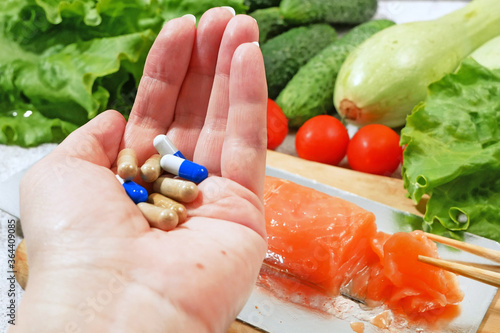 Healthy food vs pills. Salmon, vegetables and fruis vs medicine and drugs. Concept photo