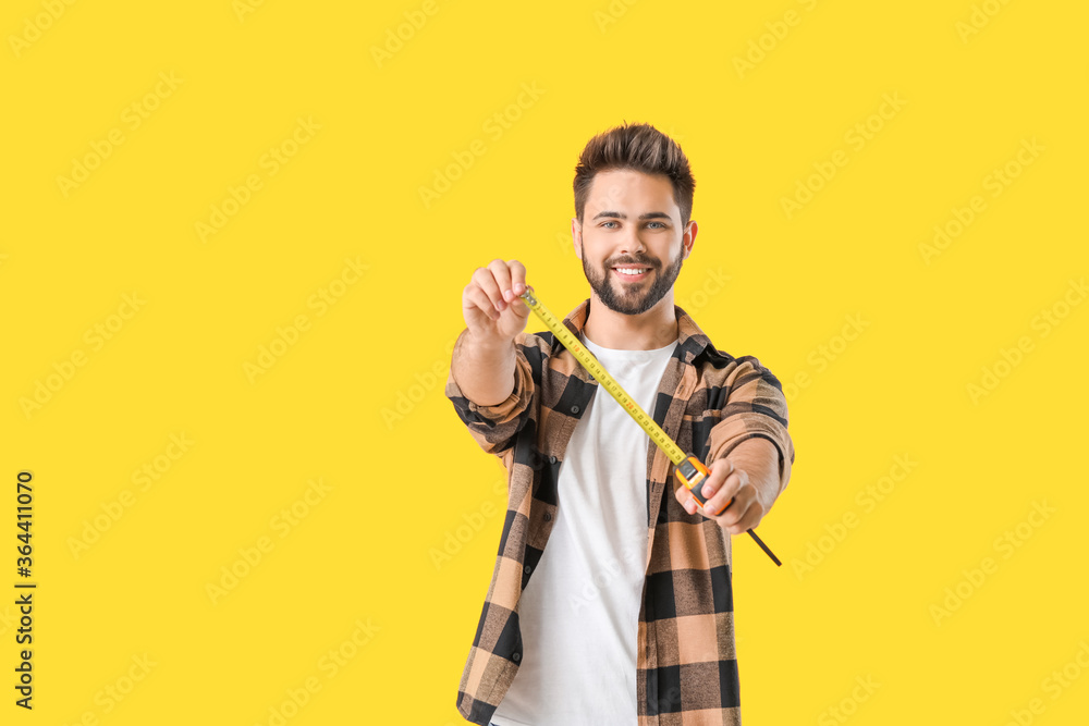 Young man with measuring tape on color background Young man with measuring tape on color background