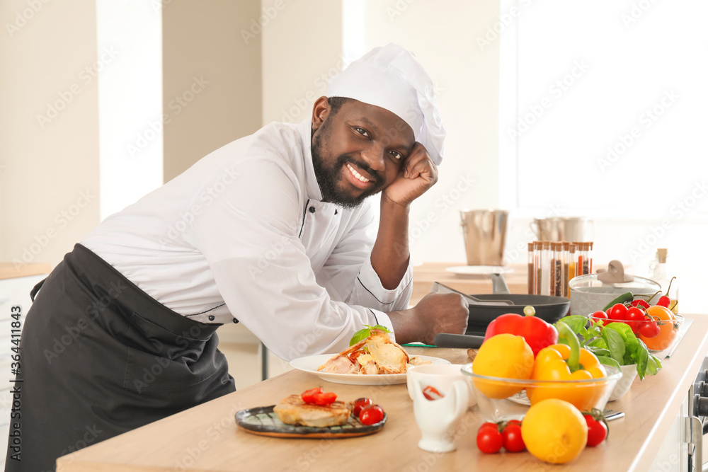 Male African-American chef with tasty dish in kitchen Male African-American chef with tasty dish in kitchen