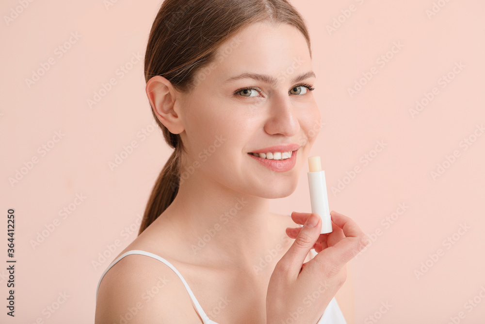 Beautiful young woman with lip balm on color background Beautiful young woman with lip balm on color background