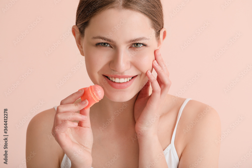 Beautiful young woman with lip balm on color background Beautiful young woman with lip balm on color background