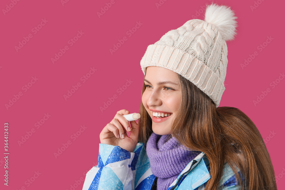 Beautiful young woman with lip balm on color background Beautiful young woman with lip balm on color background