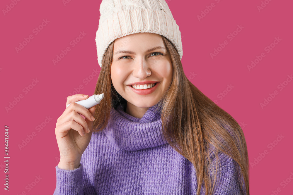 Beautiful young woman with lip balm on color background Beautiful young woman with lip balm on color background