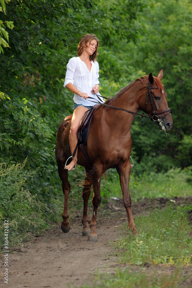 Beautiful young girl with blond hair in a jacket with a shorts, smiling and riding her horse. Equestrian, lifestyle. Beautiful young girl with blond hair in a jacket with a shorts, smiling and riding her horse. Equestrian, lifestyle.