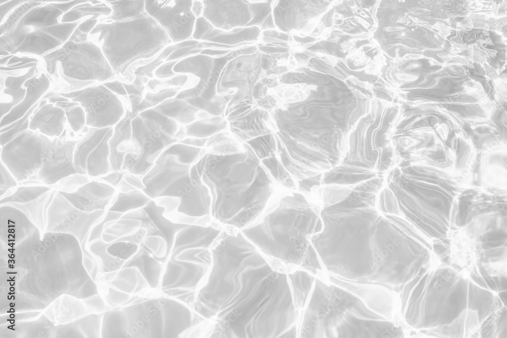 Closeup of desaturated transparent clear calm water surface texture with splashes and bubbles. Trendy abstract nature background. White-grey water waves in sunlight