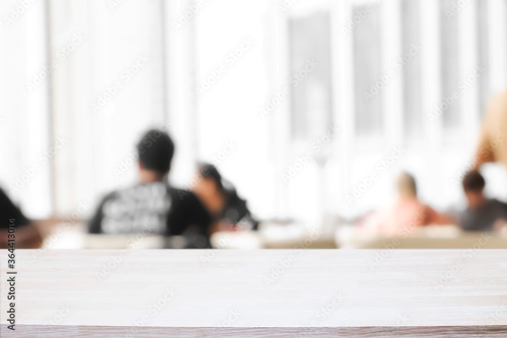 Fototapeta premium Empty wooden desk space and blurry background of cafe or Restaurant for product display montage.