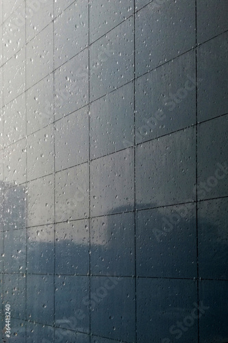 buildings are reflected in the glossy wall of a skyscraper
