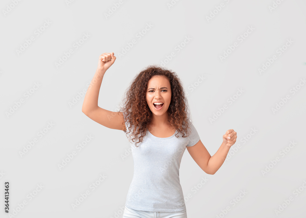 Angry protesting African-American woman on light background Angry protesting African-American woman on light background
