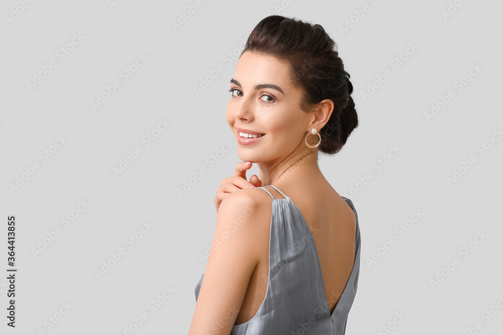 Beautiful young woman with stylish hairdo on grey background Beautiful young woman with stylish hairdo on grey background