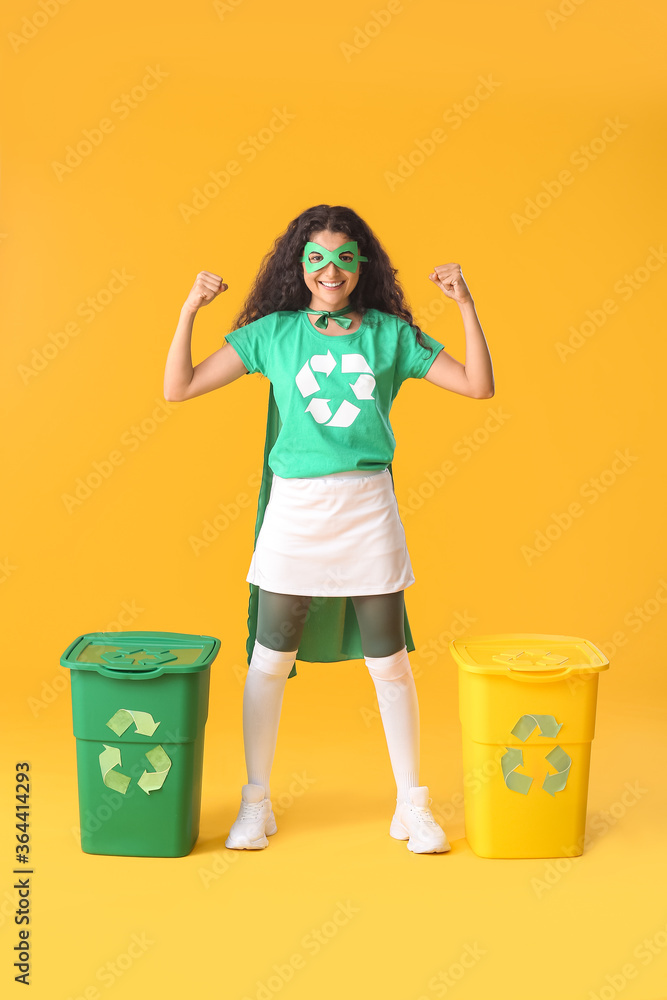 Woman dressed as eco superhero with trash bins on color background Woman dressed as eco superhero with trash bins on color background