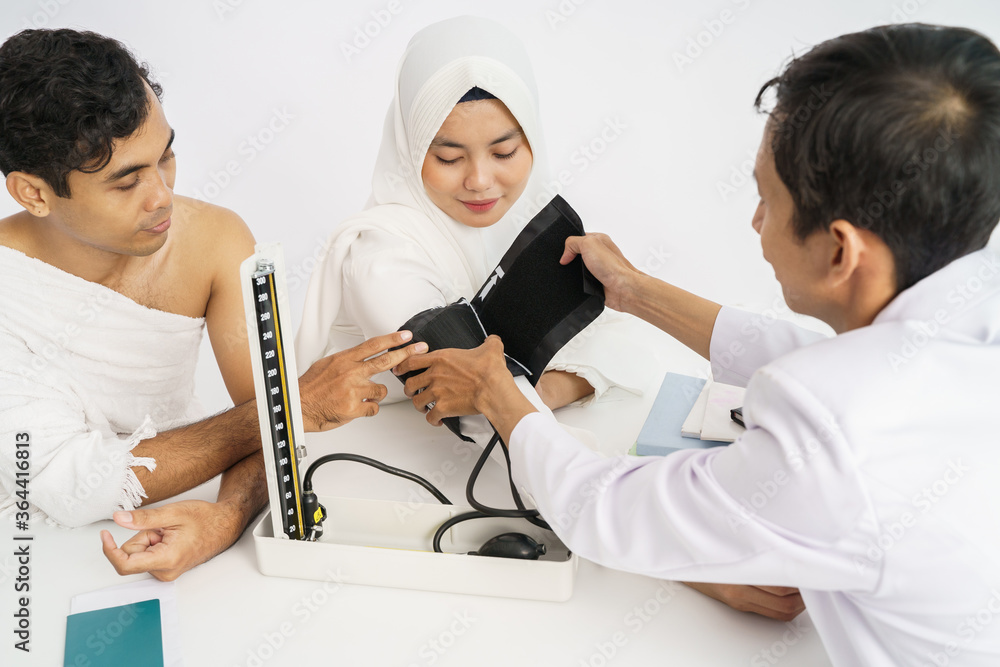 Obraz premium patient checkup for blood pressure test at clinic before traveling for umrah and hajj