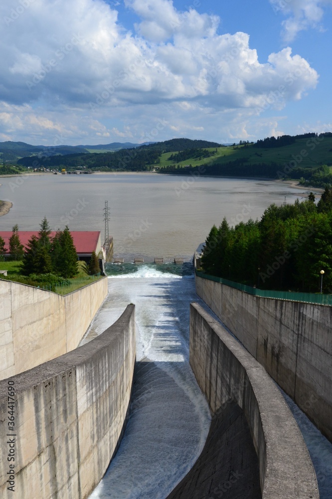 Water overflow in the dam. Opened water dam. Dam and water reservoir in Niedzica was created in order to reduce flood culminations.  Czorsztyn lake, southern Poland, Europe. 