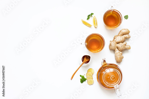 Ginger tea in a glass teapot on a white background.