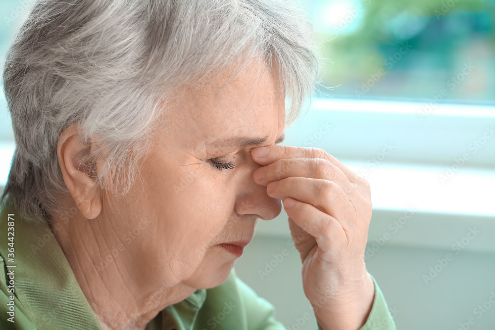 Senior woman suffering from headache at home Senior woman suffering from headache at home