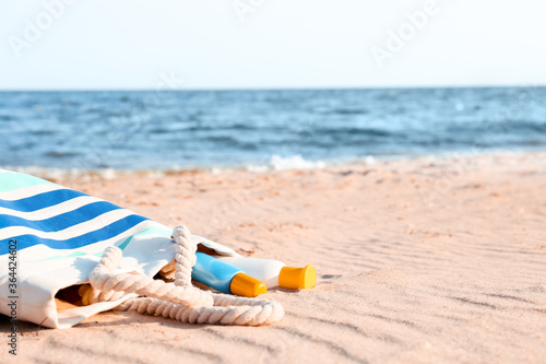 Bag with sunscreen cream on beach