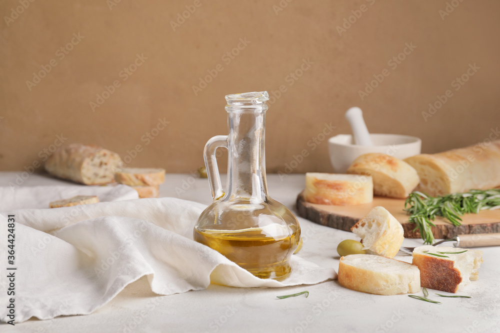 Obraz premium Bottle of tasty olive oil and bread on table