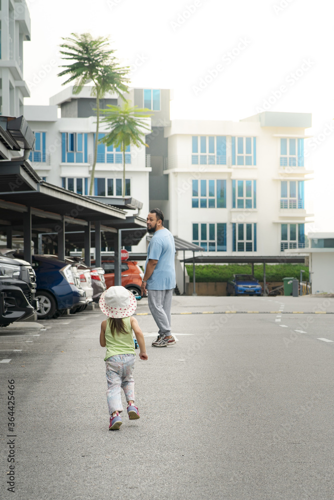 Dad walks with her daughter in the neighbourhood.