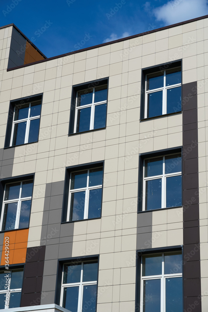 facade of a modern building on a bright Sunny day, siding and Windows, beautiful exterior of the new building facade of a modern building on a bright Sunny day, siding and Windows, beautiful exterior of the new building
