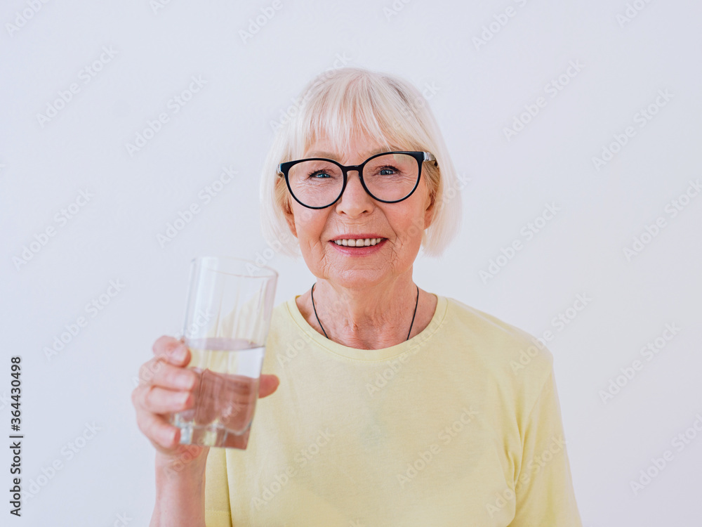senior woman holding glass of water and drinking water. Healthy lifestyle, sport, anti age concept senior woman holding glass of water and drinking water. Healthy lifestyle, sport, anti age concept