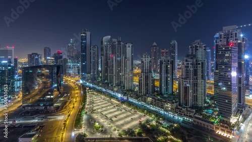 Wallpaper Mural Illuminated residential and office towers aerial timelapse during all night with lights switching off at Business Bay, Dubai, UAE. Bay Avenue Park near big parking lot with cars and traffic on roads Torontodigital.ca