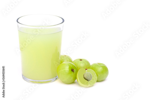 Closeup fresh organic Indian gooseberry fruits ( Amla ) and glass of gooseberry juice isolated on white background. Antioxidant fruit, herbal medicine plant and healthy drinks concept. 