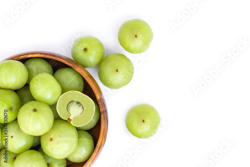 Close up  Indian gooseberry fruits ( Amla, phyllanthus emblica ) and cut i n half slice in wooden bowl isolated on white background. Top view. Flat lay.