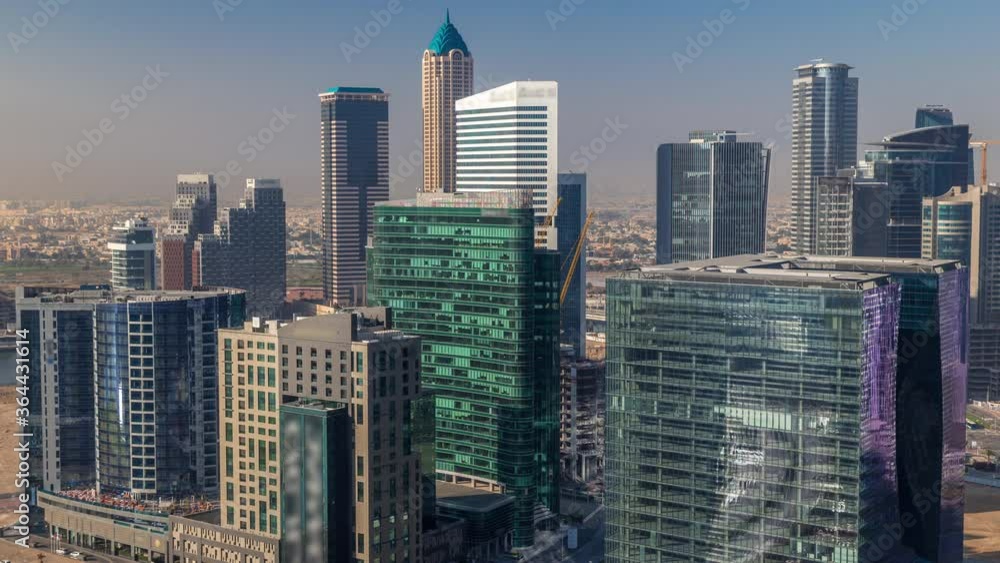 Dubai's business bay towers at morning aerial timelapse. Rooftop view of some skyscrapers and new towers under construction. Hazy weather with shadows mooving fast Dubai's business bay towers at morning aerial timelapse. Rooftop view of some skyscrapers and new towers under construction. Hazy weather with shadows mooving fast
