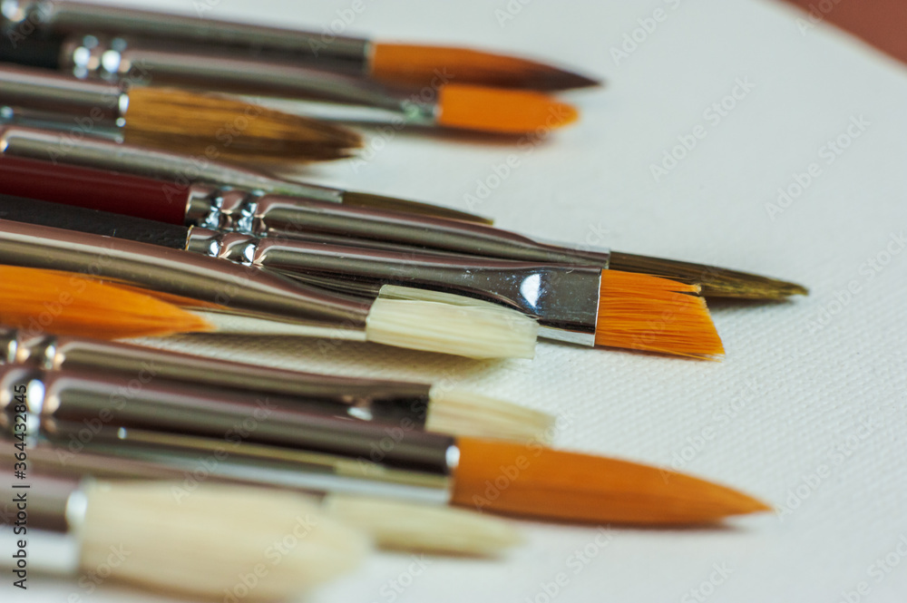 Brushes for the artist. Artistic brushes are placed in a professional case on a brown background. Brushes for the artist. Artistic brushes are placed in a professional case on a brown background.