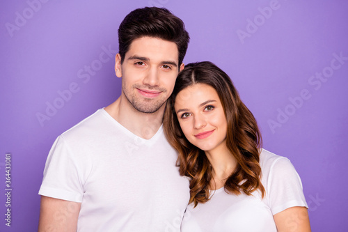 Portrait of peaceful trust beloved married students couple enjoy togetherness look in camera wear stylish clothes isolated over purple color background