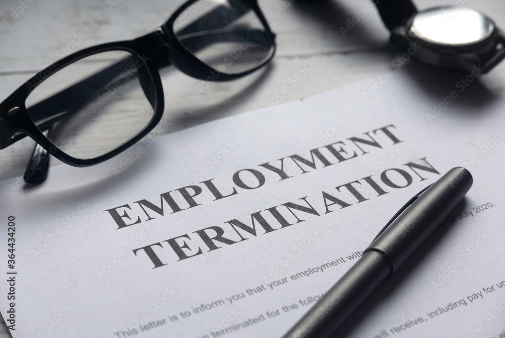 Selective focus of glasses,watch,pen and Employment Termination letter on a white wooden background. Selective focus of glasses,watch,pen and Employment Termination letter on a white wooden background.