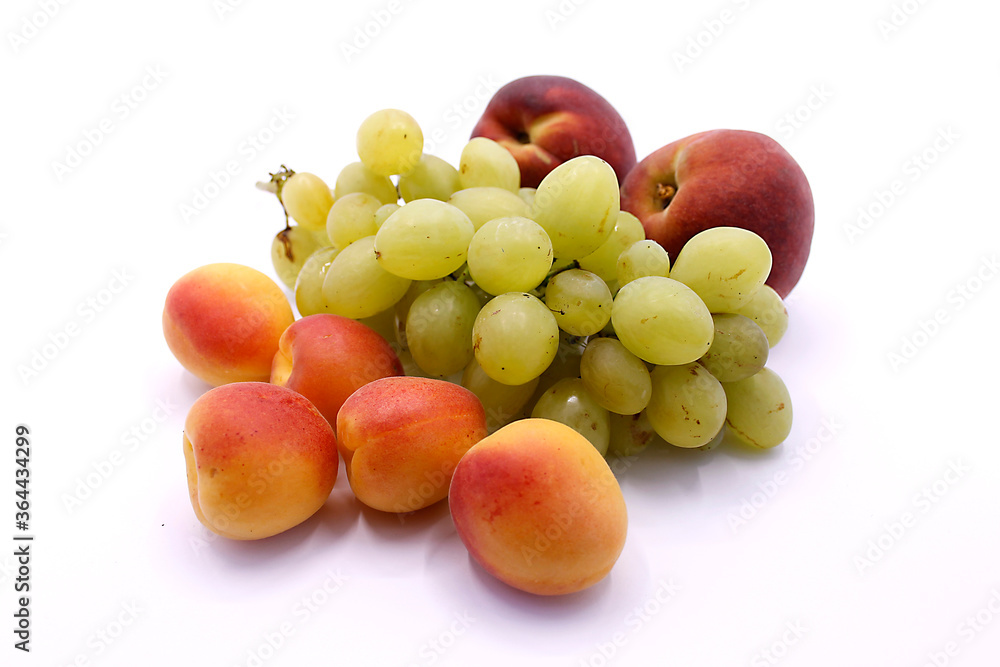 Grape bunch, peaches and ripe apricot close-up on a white background