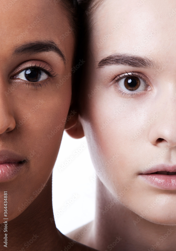 Close up of black and white female faces together Close up of black and white female faces together