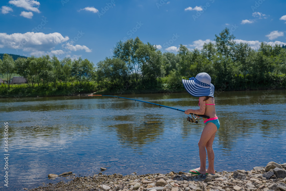 Cute little child girl fishing on the river Cute little child girl fishing on the river