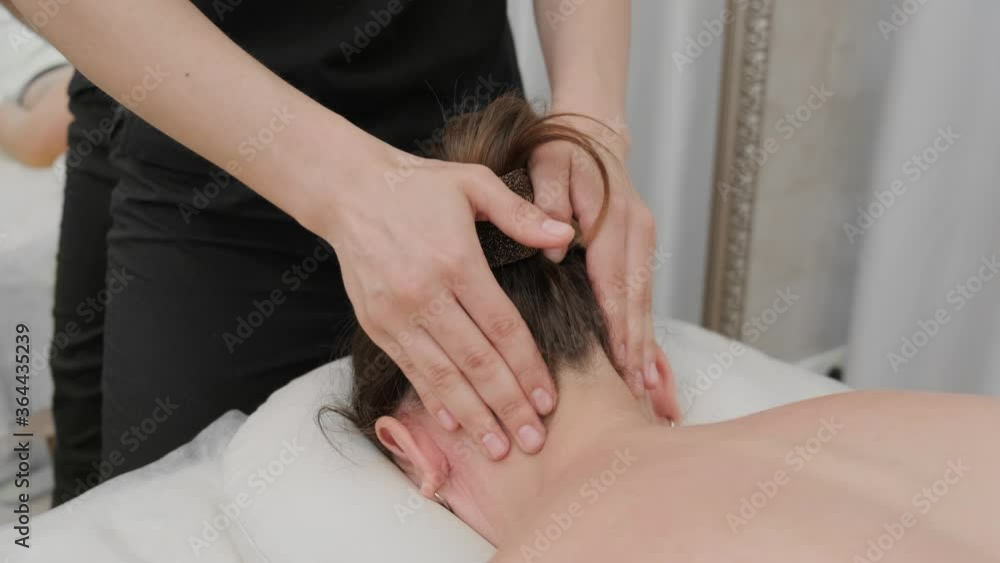 Female therapist massages the head and face of a young woman. Relaxing massage. Therapeutic massage. Alternative medicine. Spa treatments. Female therapist massages the head and face of a young woman. Relaxing massage. Therapeutic massage. Alternative medicine. Spa treatments.