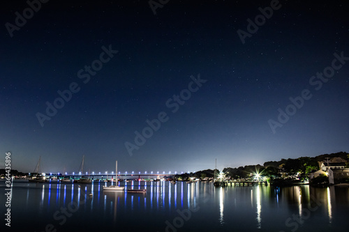 Bahía en la noche visualizando puente y barcos 