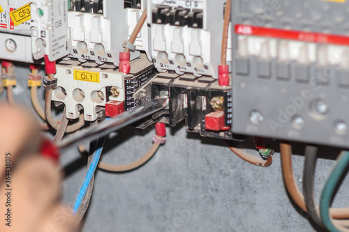 a professional electrician man is fixing the critical wiring connections of a electrical circiut board