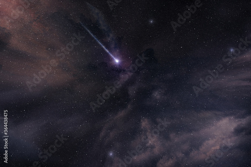falling star shining in starry and cloudy night sky, comet in a purple nebula